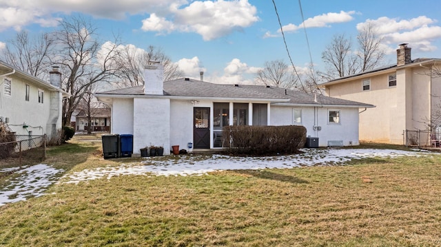 rear view of house featuring a lawn