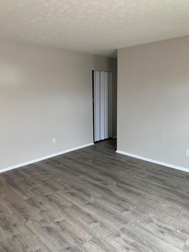 empty room featuring wood-type flooring and a textured ceiling