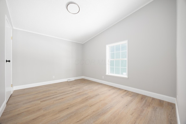 unfurnished room with light wood-type flooring and lofted ceiling