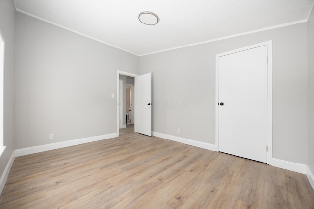 spare room with crown molding and light hardwood / wood-style flooring