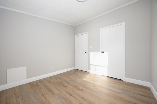 empty room with light hardwood / wood-style floors and ornamental molding