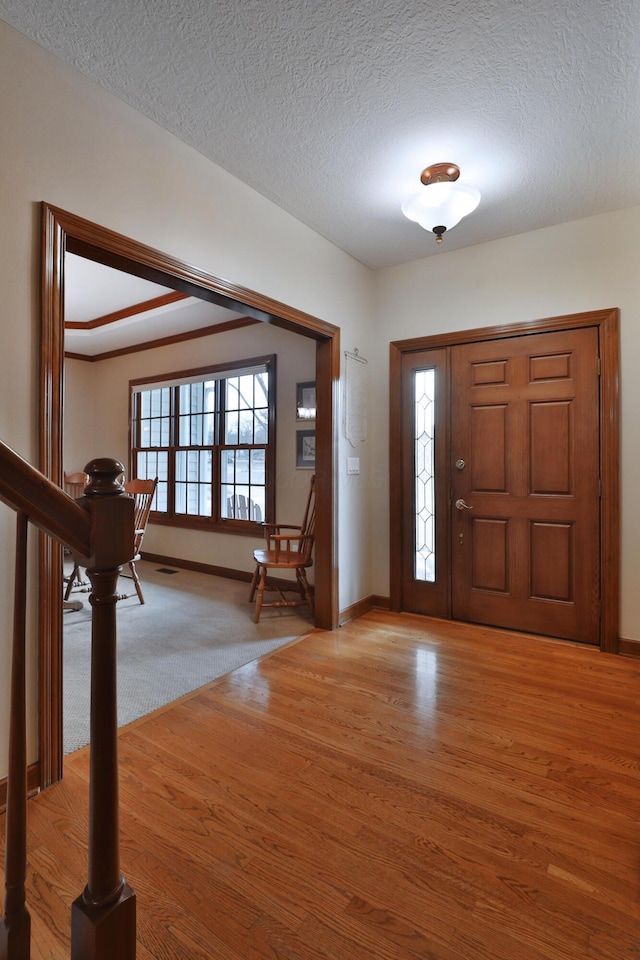 entrance foyer featuring a textured ceiling and light wood-type flooring