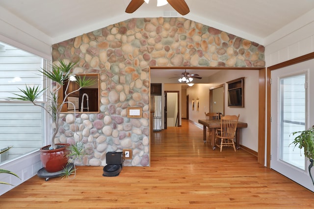 interior space with lofted ceiling, stainless steel refrigerator, ceiling fan, and light hardwood / wood-style flooring