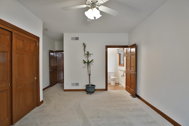 carpeted bedroom with connected bathroom and ceiling fan