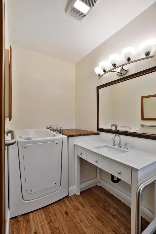 washroom featuring washer / clothes dryer, sink, and dark hardwood / wood-style flooring