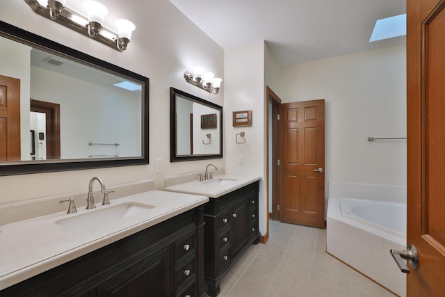 bathroom with vanity, tiled bath, and tile patterned floors