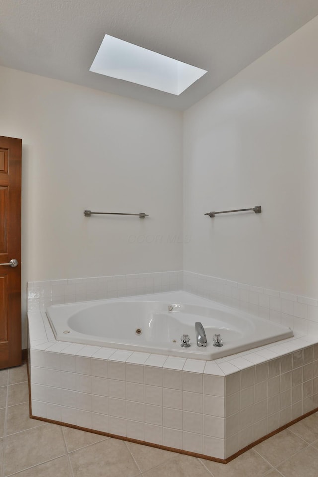 bathroom with tiled tub and tile patterned floors