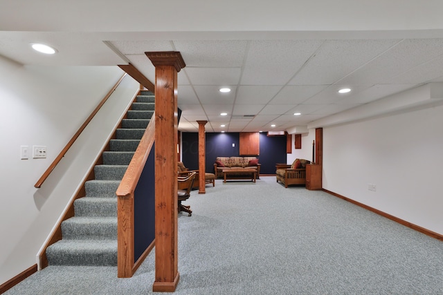 living room featuring carpet flooring and a drop ceiling