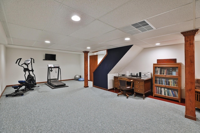 workout room featuring a drop ceiling, carpet, and ornate columns