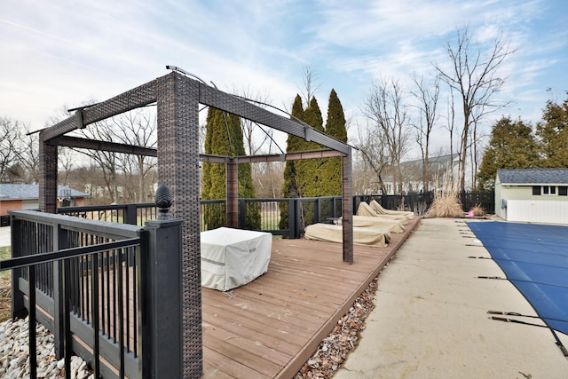 wooden terrace with an outdoor structure and a covered pool