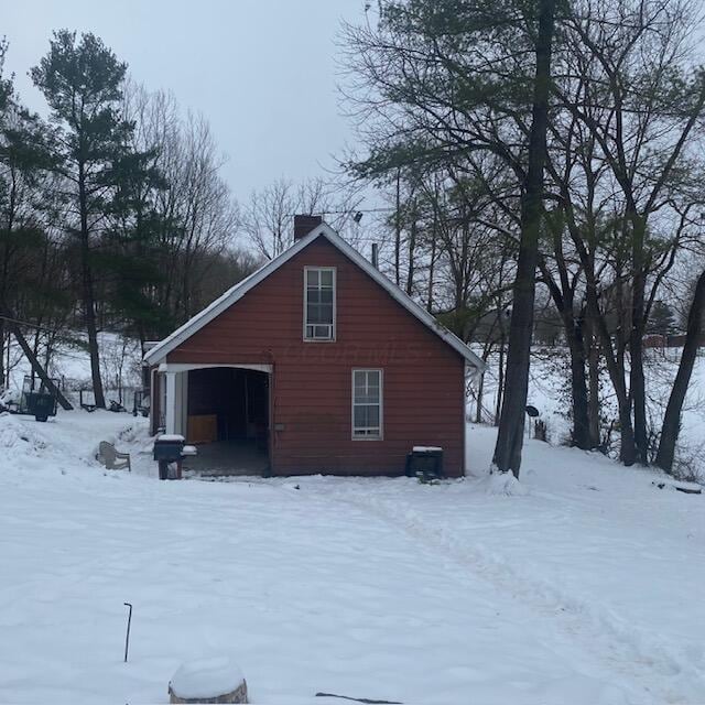 view of snow covered back of property