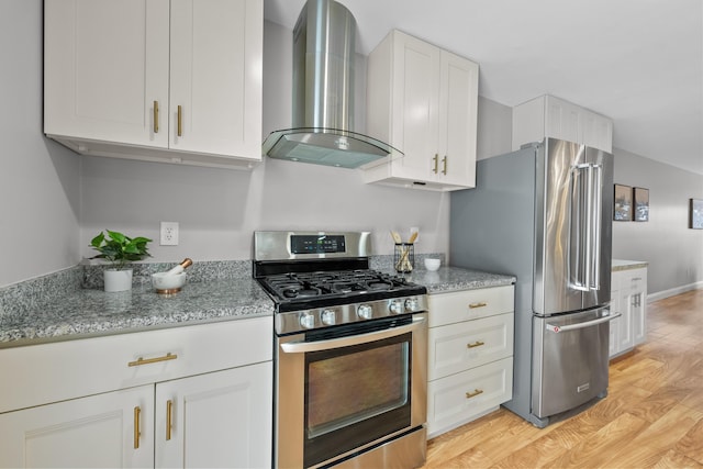 kitchen featuring light stone countertops, appliances with stainless steel finishes, light wood-type flooring, wall chimney range hood, and white cabinetry