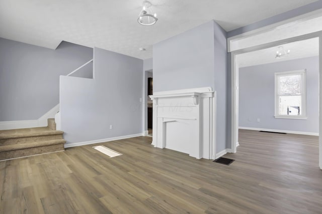 unfurnished living room with a fireplace, dark hardwood / wood-style flooring, and a textured ceiling