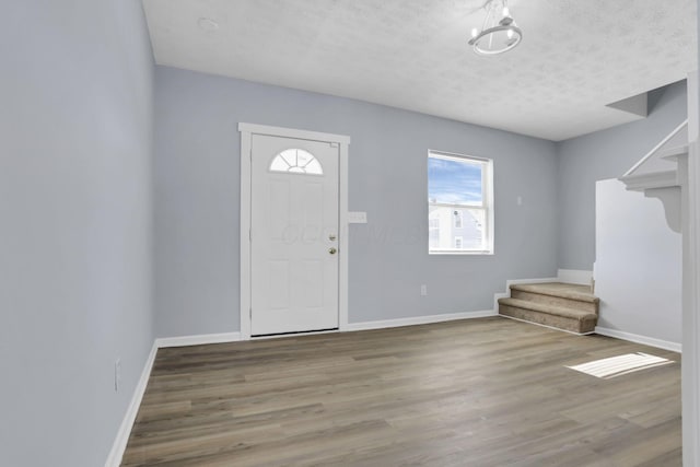 entrance foyer featuring light wood-type flooring and a textured ceiling