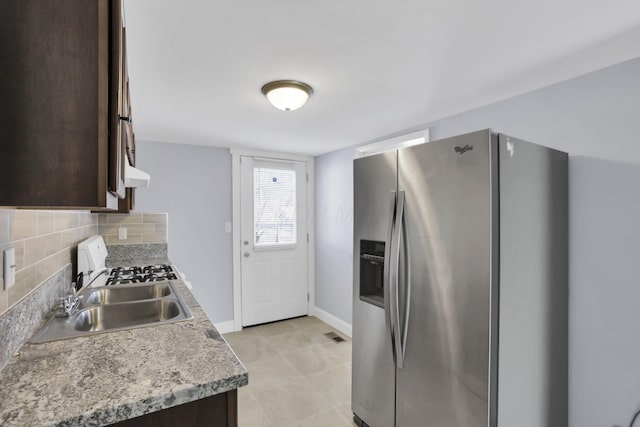 kitchen with sink, wall chimney range hood, tasteful backsplash, stainless steel refrigerator with ice dispenser, and dark brown cabinets