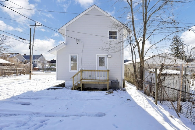 snow covered rear of property featuring cooling unit