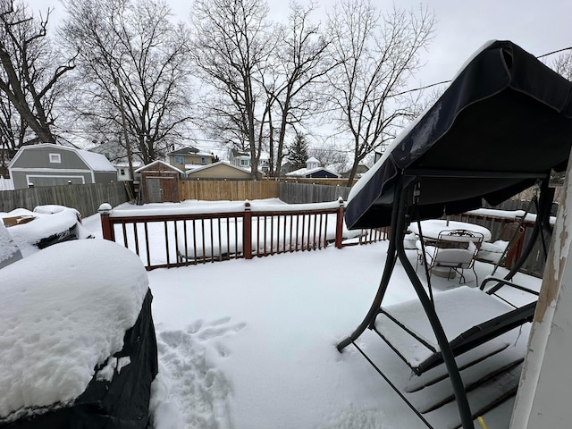 snow covered deck with a storage shed