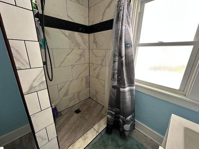 bathroom featuring a tile shower and hardwood / wood-style floors