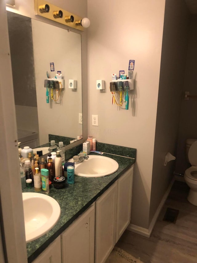 bathroom with vanity, hardwood / wood-style floors, and toilet