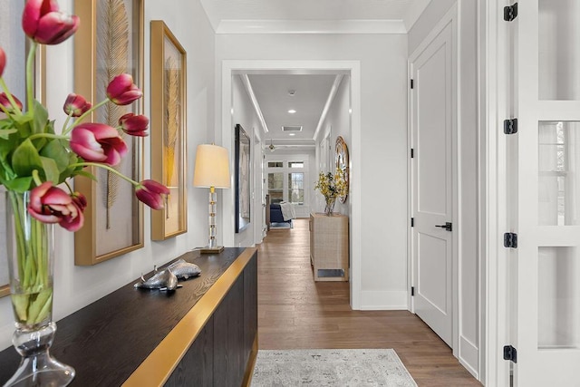 corridor featuring ornamental molding and dark hardwood / wood-style flooring