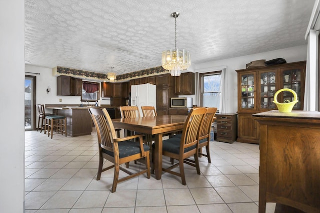 tiled dining area featuring a chandelier