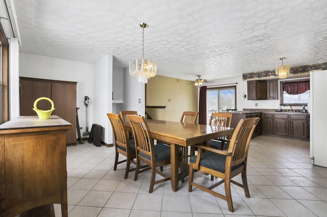 tiled dining area with sink and ceiling fan with notable chandelier