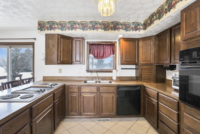 kitchen with light tile patterned flooring, sink, a textured ceiling, and black appliances