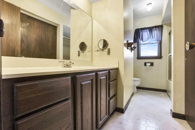 full bathroom with vanity, enclosed tub / shower combo, and toilet