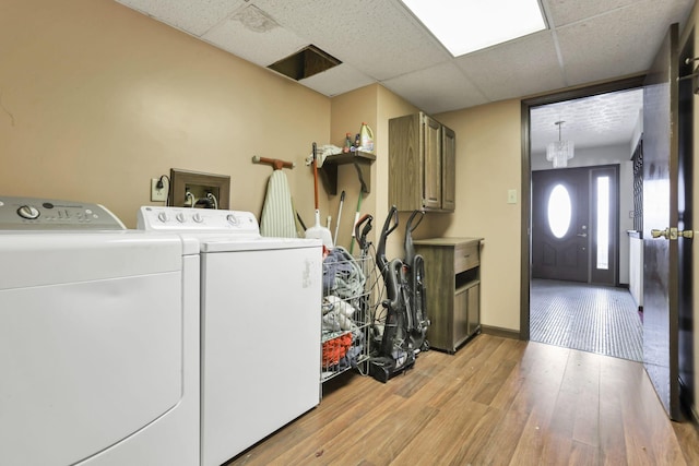 laundry area featuring washing machine and clothes dryer and light wood-type flooring