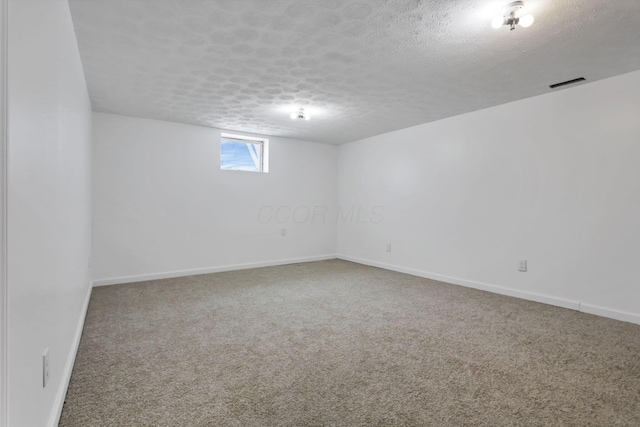 basement featuring carpet and a textured ceiling