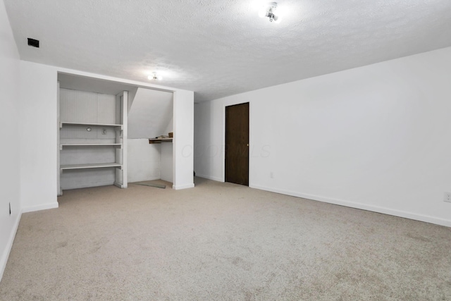 unfurnished bedroom featuring light carpet and a textured ceiling