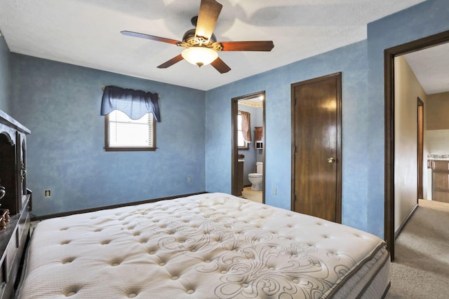 carpeted bedroom featuring ceiling fan and ensuite bathroom