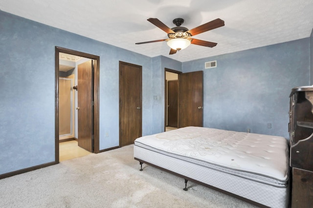 carpeted bedroom with a textured ceiling and ceiling fan