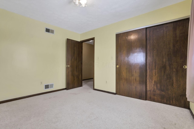 unfurnished bedroom featuring light carpet and a closet