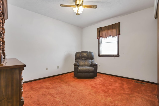 living area featuring carpet floors and ceiling fan