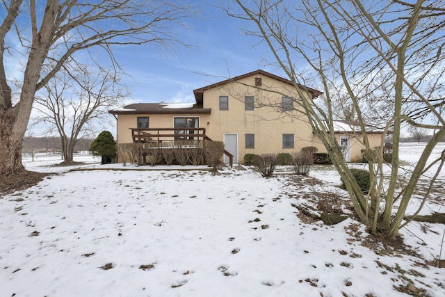 snow covered rear of property featuring a deck