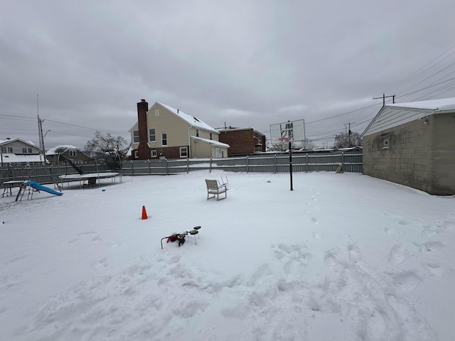 snowy yard featuring a trampoline