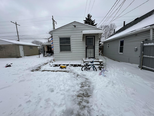 view of snow covered back of property