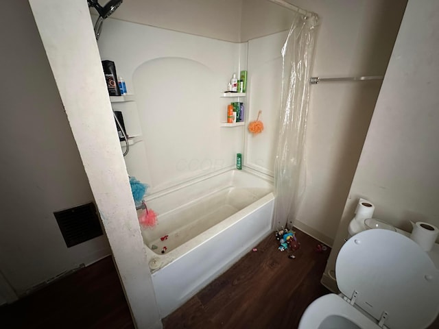 bathroom featuring toilet, wood-type flooring, and shower / bath combo