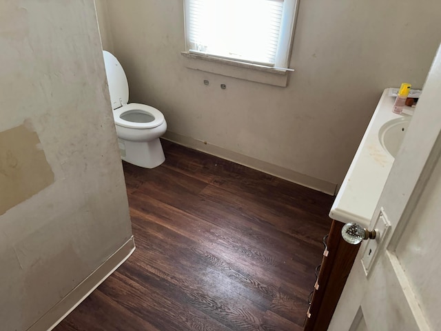 bathroom with hardwood / wood-style flooring, toilet, and vanity