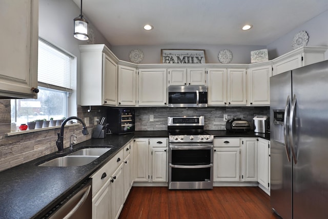 kitchen featuring sink, stainless steel appliances, white cabinetry, and decorative light fixtures