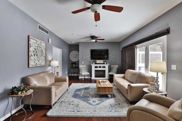 living room featuring ceiling fan and dark hardwood / wood-style flooring