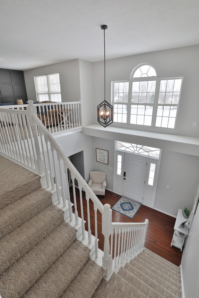 foyer entrance with an inviting chandelier and wood-type flooring