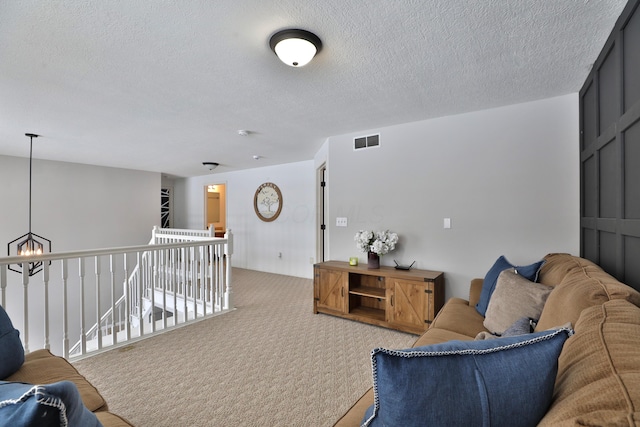 sitting room with a textured ceiling and light colored carpet