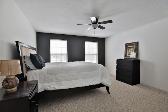 carpeted bedroom with a textured ceiling and ceiling fan