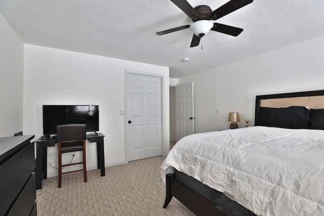 carpeted bedroom featuring a textured ceiling and ceiling fan