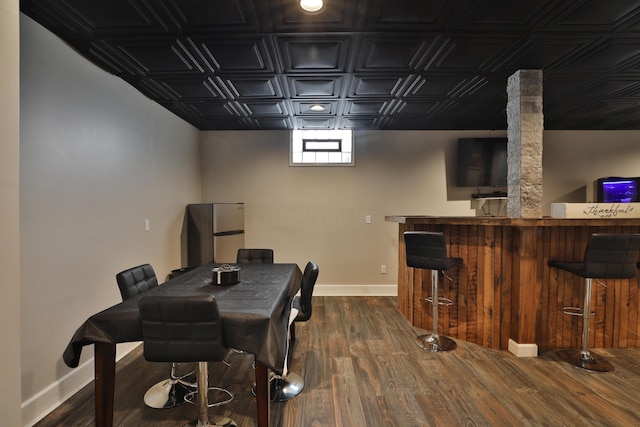 dining room with dark wood-type flooring and bar area