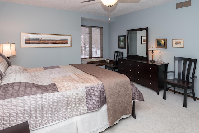 carpeted bedroom featuring ceiling fan and a textured ceiling