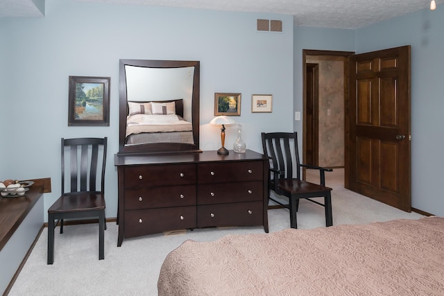 bedroom featuring light carpet and a textured ceiling