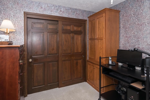 carpeted office featuring a textured ceiling